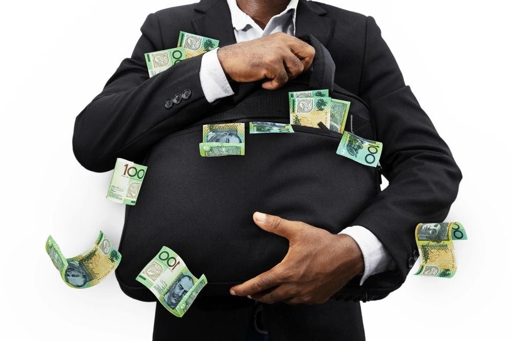 A businessman holding a bag full of cash