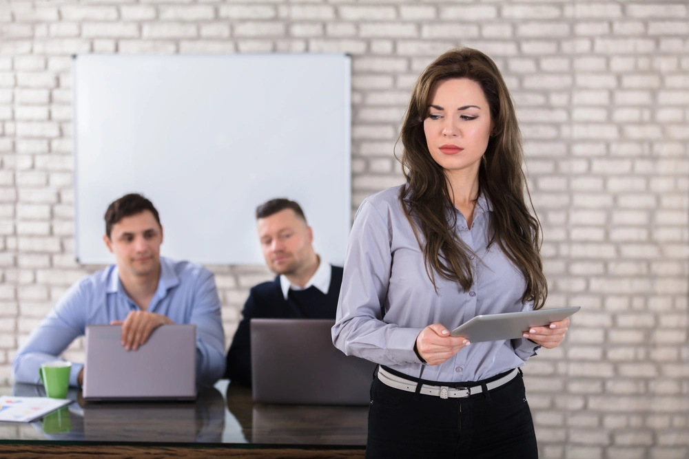 A woman is being stared at by her colleagues in an uncomfortable manner