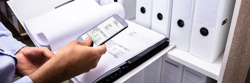 A Businessman's Hand Taking Photo Of Bill With Mobile Phone