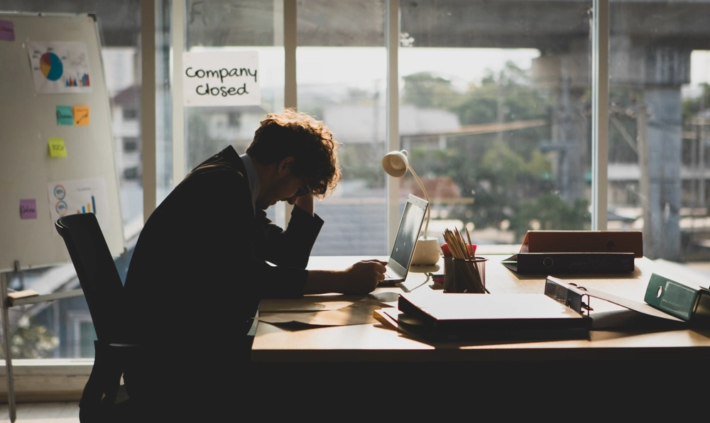 Frustrated and anxious Caucasian businessman sitting and holding hands on head