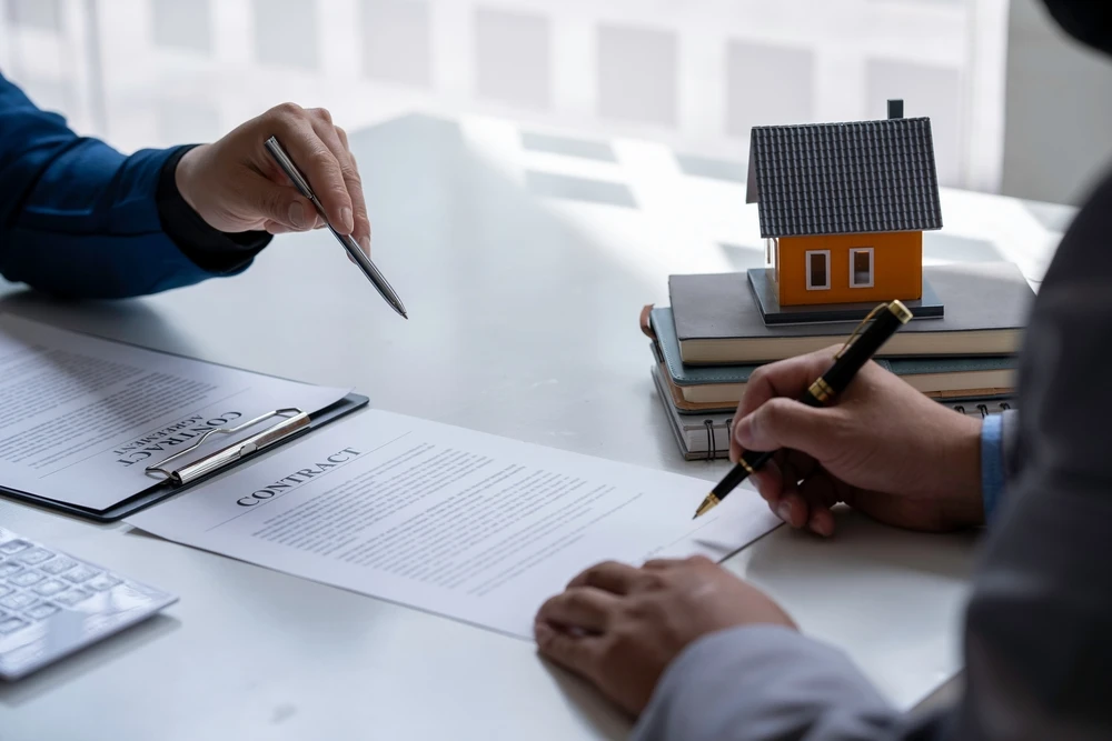 Discussion with a real estate agent, House model with agent and customer discussing for the contract to buy